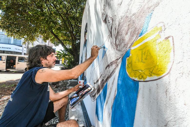 Mariano López pintando un mural de Maradona en Posadas. Créditos Marcos Otaño